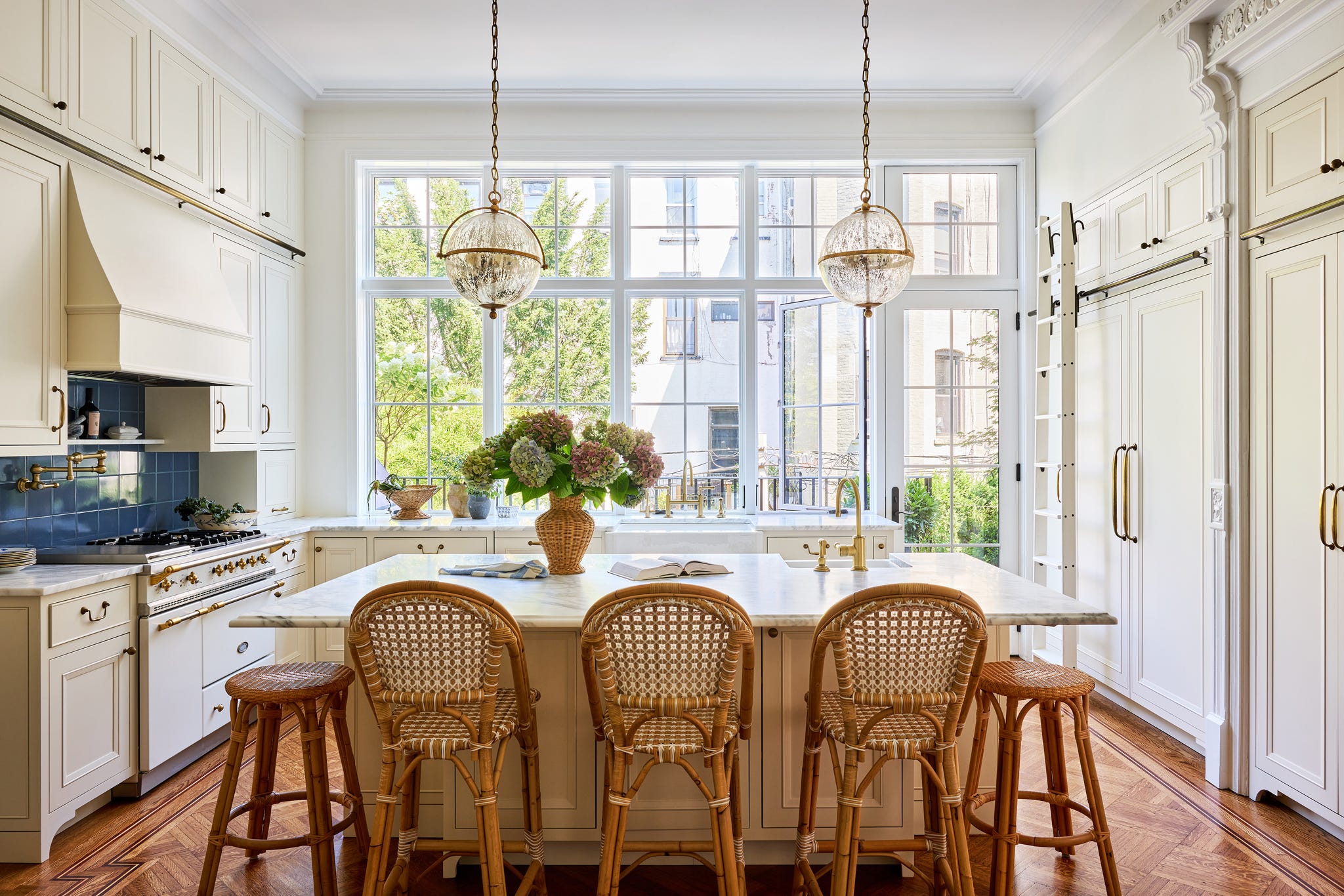 modern kitchen with an island bar stools and large windows