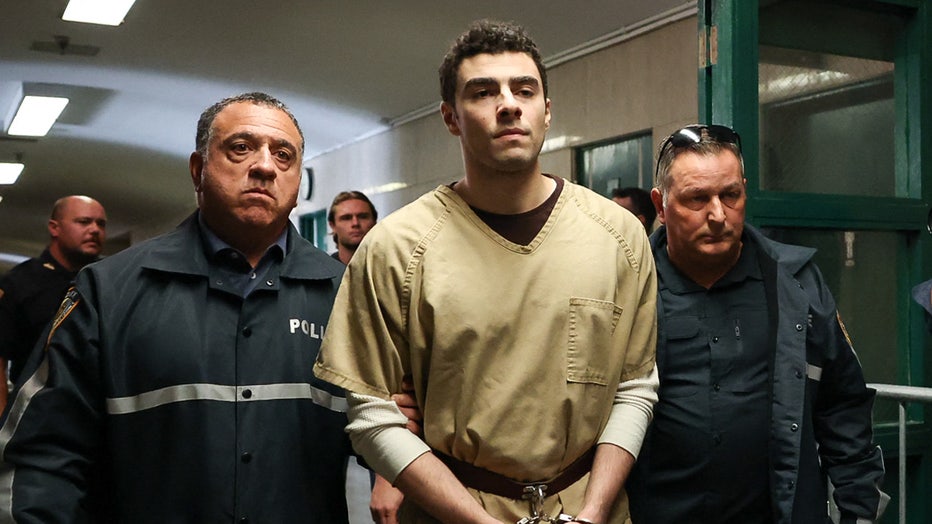 Luigi Mangione, accused of the murder of United Healthcare CEO Brian Thompson, is escorted by police as he arrives at court in New York City on September 16, 2025. Mangione is accused of shooting and killing United Healthcare CEO Brian Thompson on December 4, 2024. (Photo by TIMOTHY A.CLARY / AFP) (Photo by TIMOTHY A.CLARY/AFP via Getty Images)