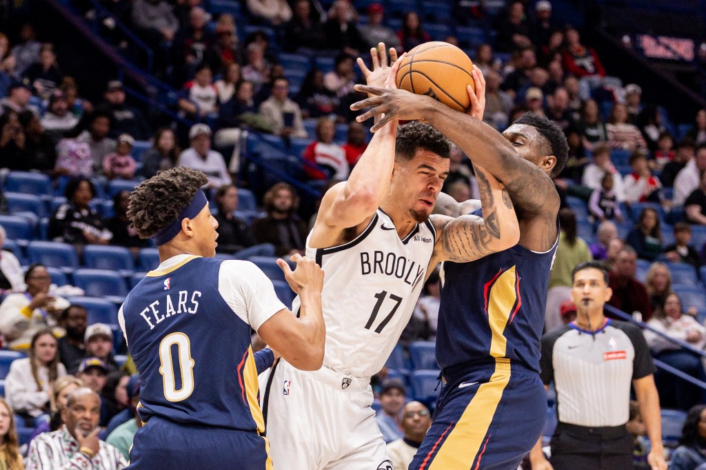 Zion Williamson (1) of the New Orleans Pelicans blocks Michael Porter Jr. (17) of the Brooklyn Nets in a basketball game.