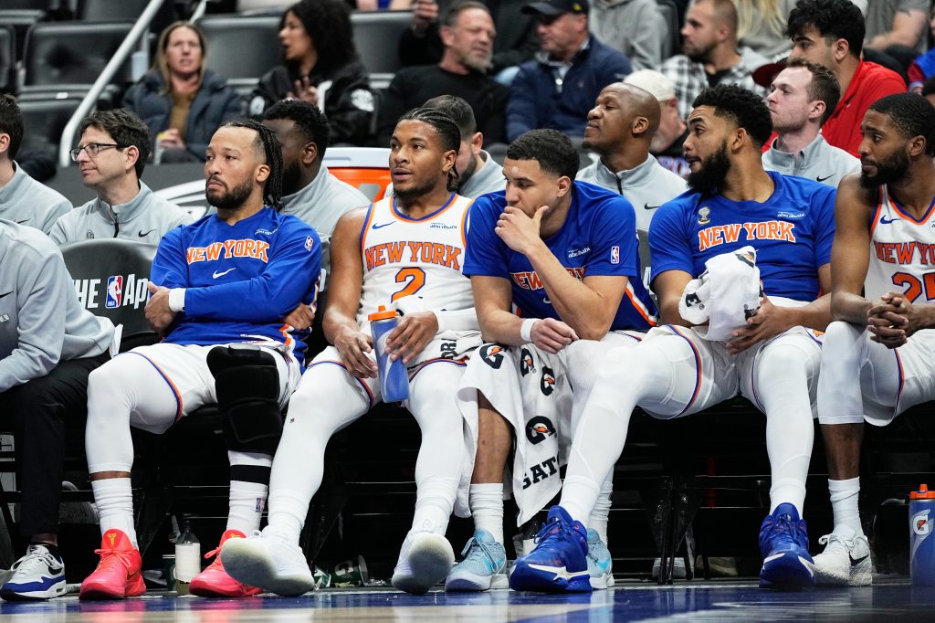 New York Knicks players Jalen Brunson, Miles McBride, Kevin McCullar Jr., Karl-Anthony Towns, and Mikal Bridges sitting on the bench.