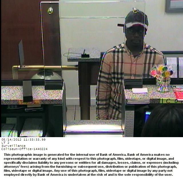 Surveillance image of the "Burberry Bandit" in a plaid shirt and cap inside a bank.