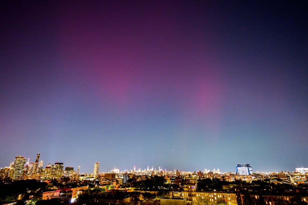 Northern Lights visible over the New York City skyline.
