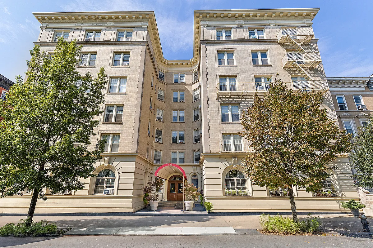building exterior with pale brick, red awning over entrance