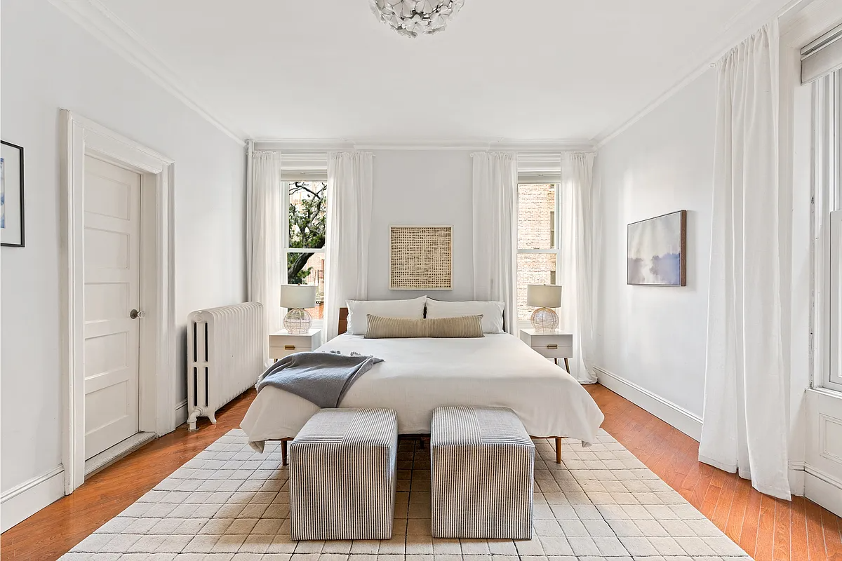 bedroom with wood floor, two windows