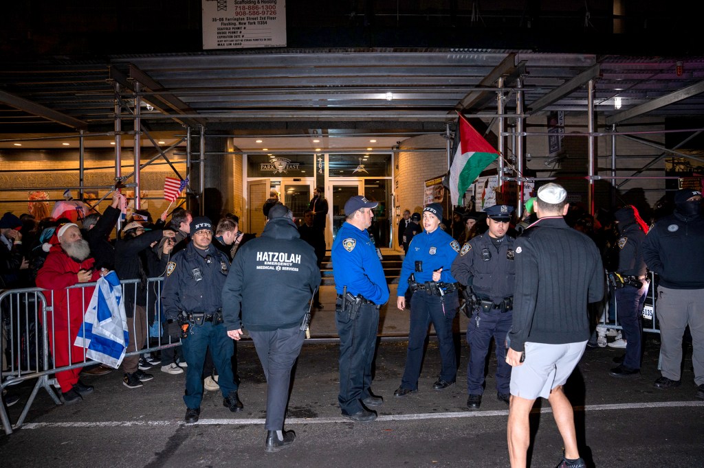 Police officers separate pro-Palestinian and counter-protesters outside a synagogue.