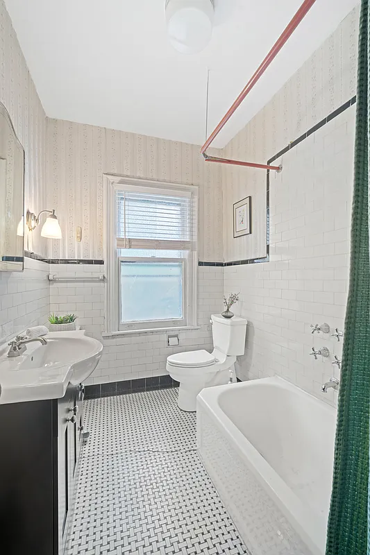 bathroom with white fixtures, black and white tile