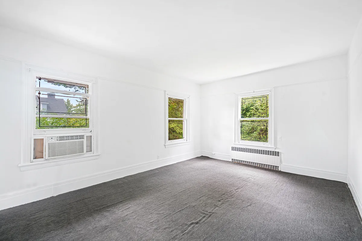 bedroom with gray carpet, two exposures