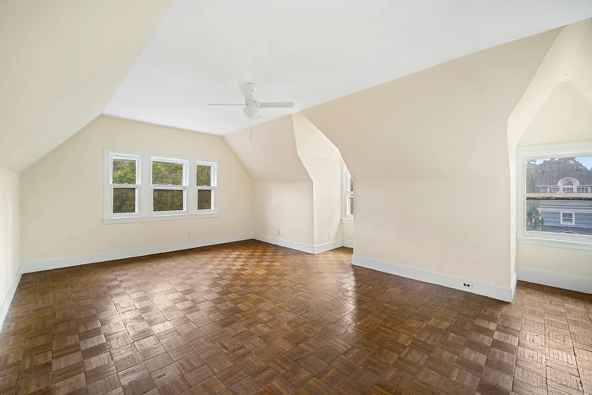 top floor bedroom with parquet floor, ceiling fan, two exposures