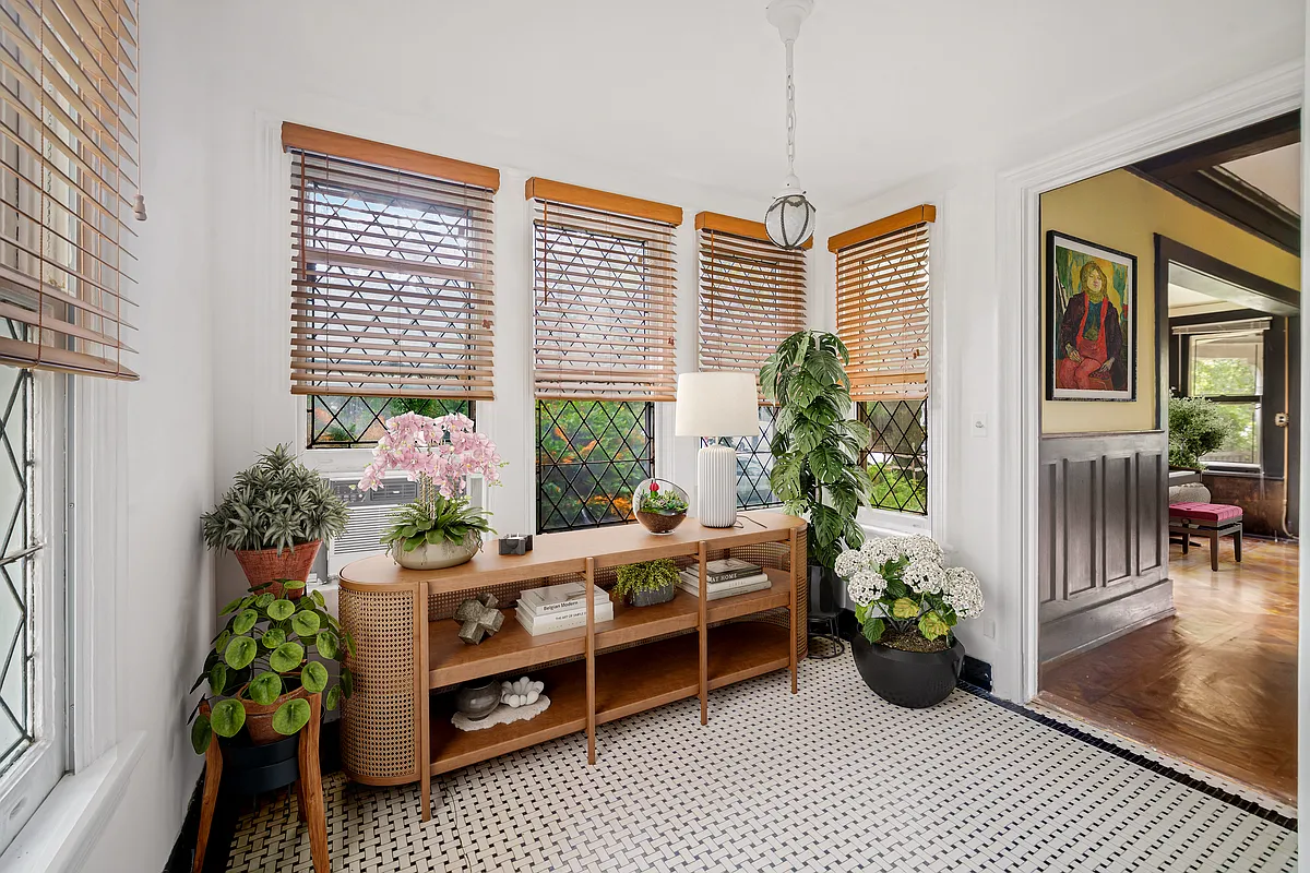 small sun room with mosaic tile floor virtually staged with storage and plants