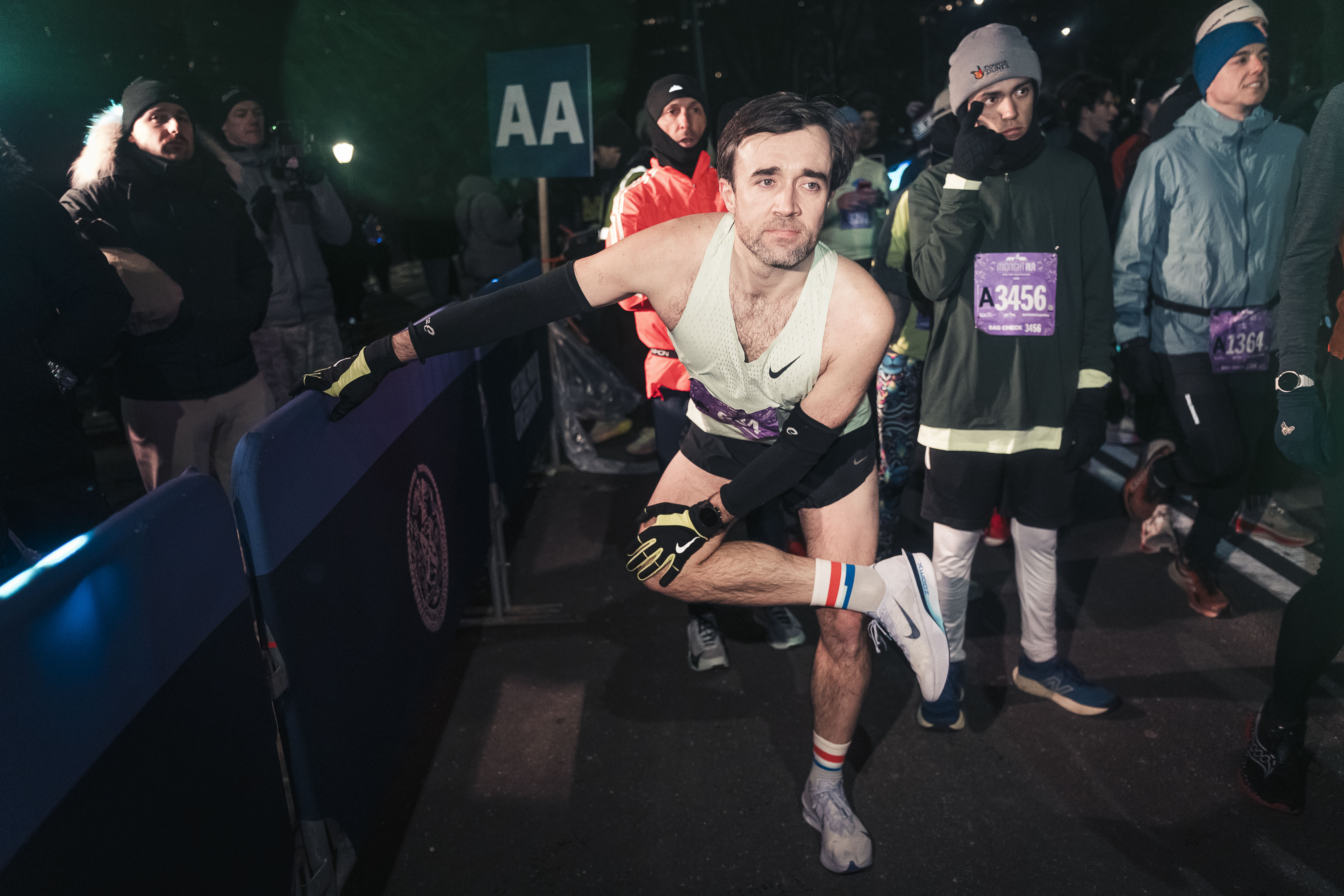 At the start line, runners stretch and prepare for the race into 2026.