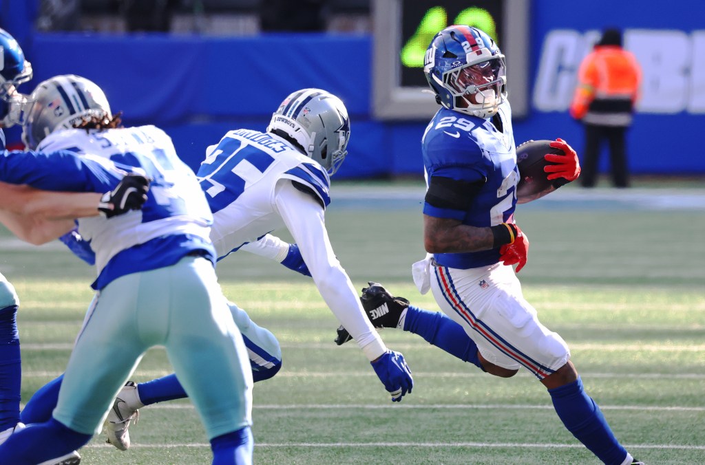 Giants running back Tyrone Tracy (r.) runs the ball against the Cowboys on Jan. 4, 2026.