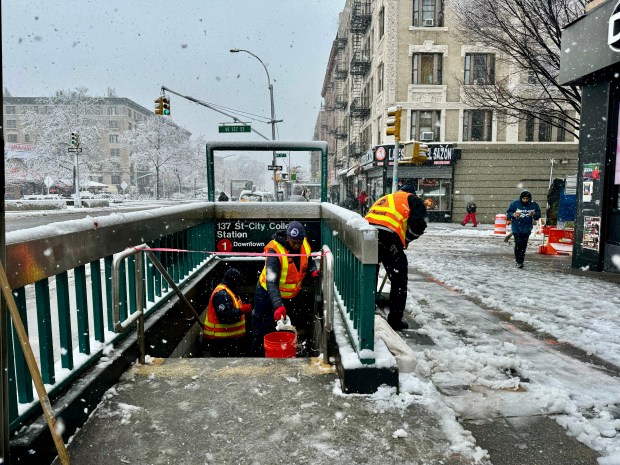 Transit workers clear a subway entrance of snow and ice. (Shutterstock) 