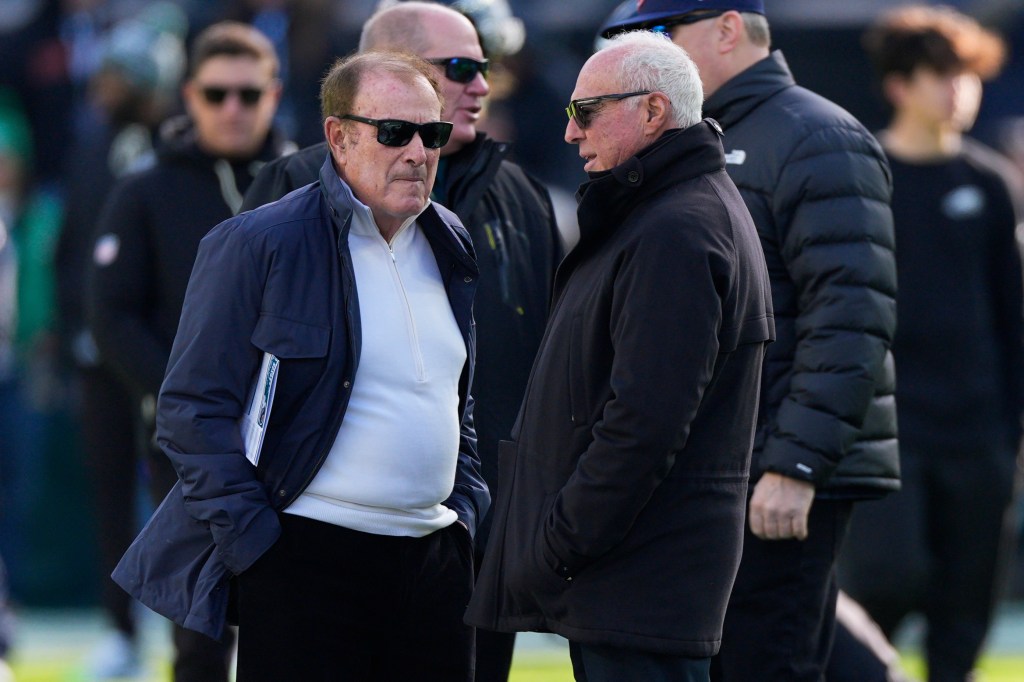 Sportscaster Al Michaels and Philadelphia Eagles owner Jeffrey Lurie talk before an NFL football game.