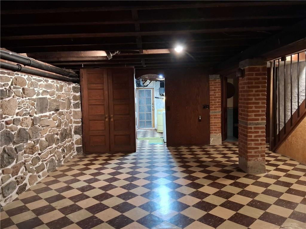 basement rumpus room with rubble stone walls and tile floor