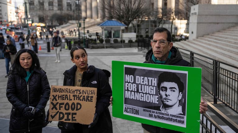 Supporters of Luigi Mangione raise signs outside Manhattan federal court, Friday, Jan. 9, 2026, in New York.