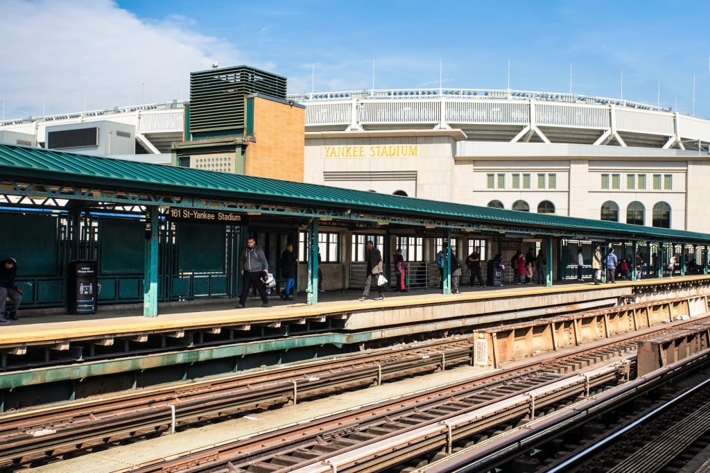Train station platform at Yankee Stadium in the Bronx, New York, with people.