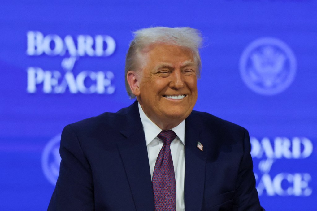 Donald Trump smiling against a blue background with "BOARD of PEACE" written on it.