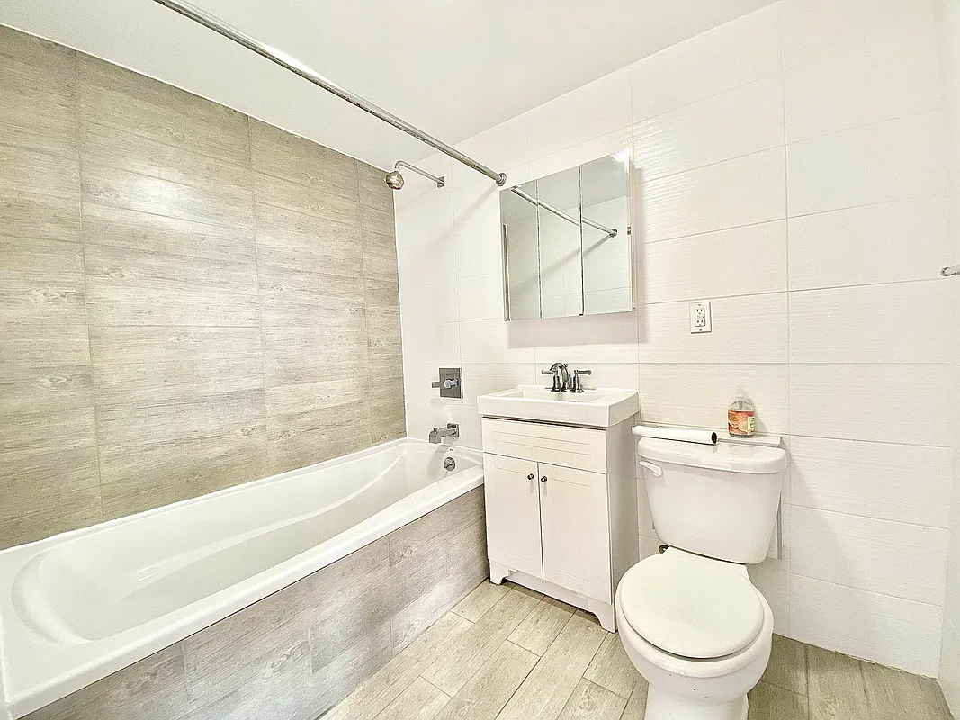 bathroom with beige tile and white fixtures