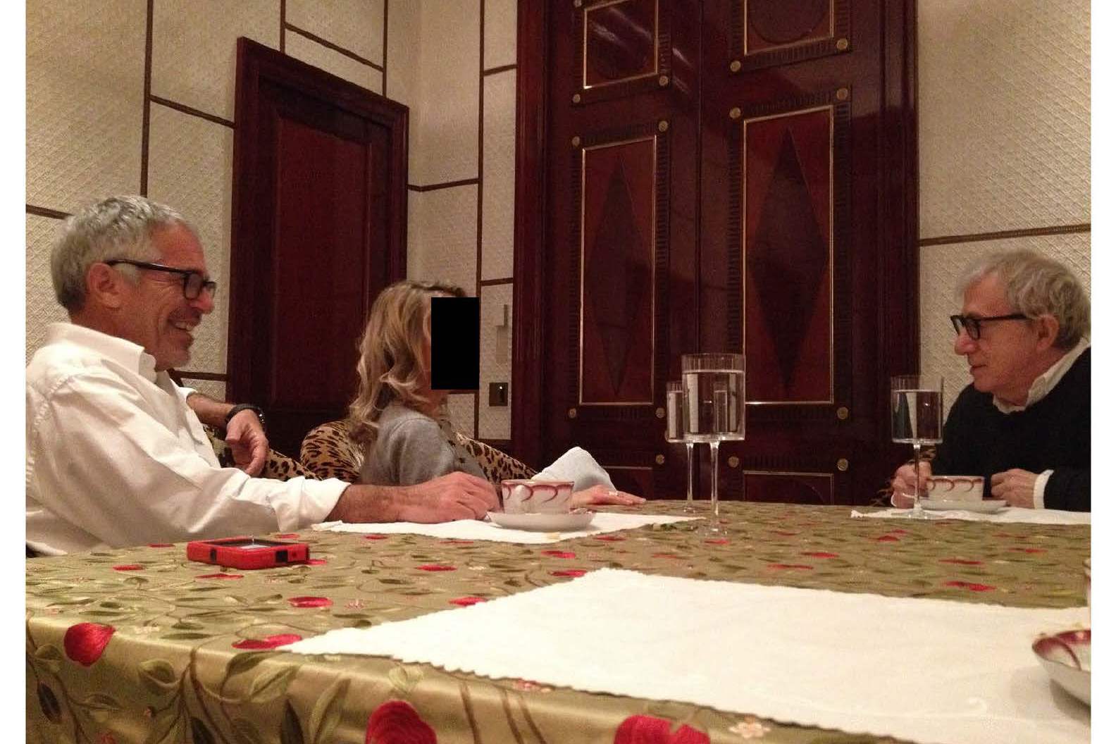 Jeffrey Epstein, an unidentified woman, and Woody Allen seated around a dining table.
