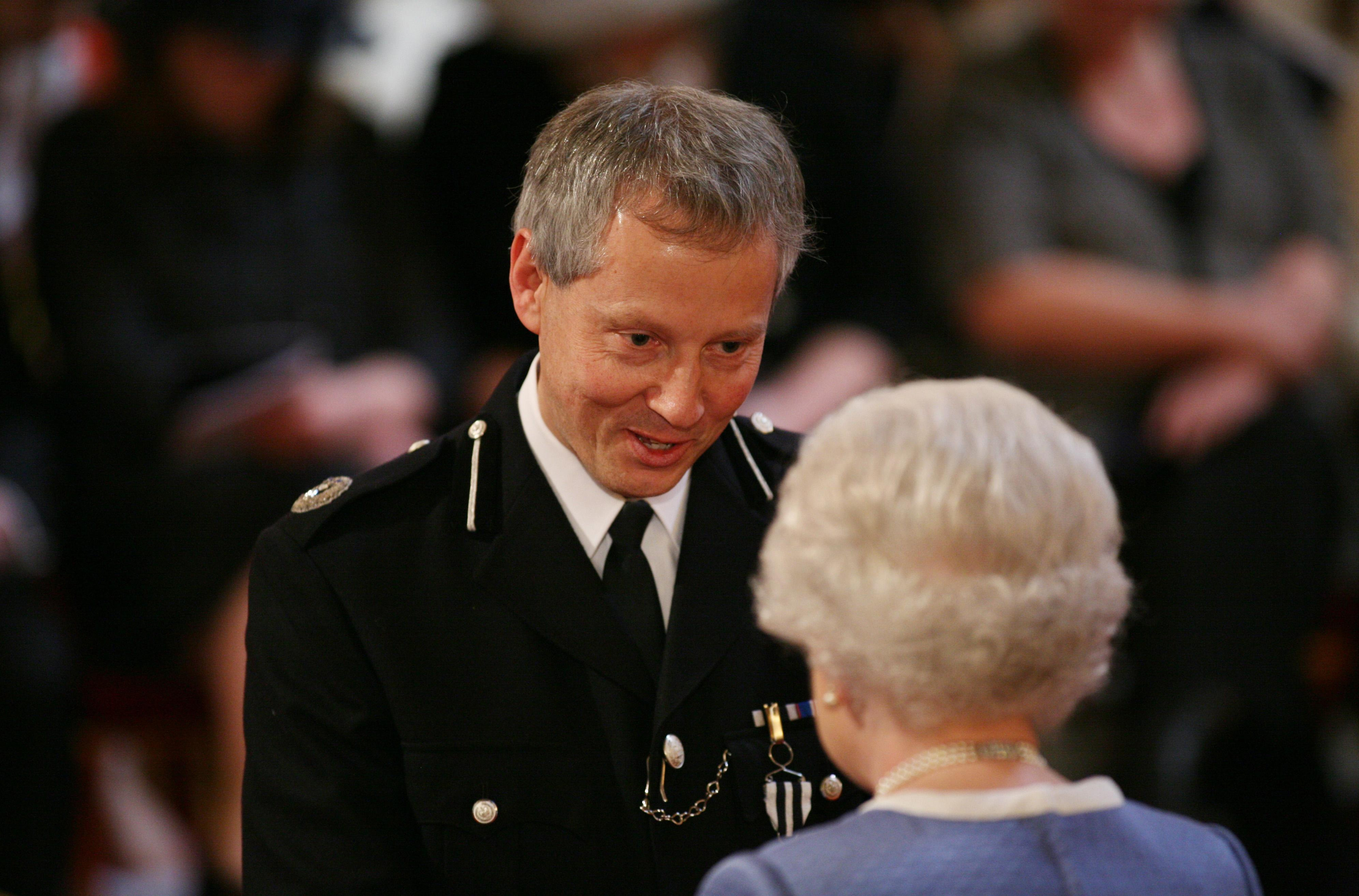 Commander Peter Loughborough receives the Queen's Police Medal from Queen Elizabeth II.