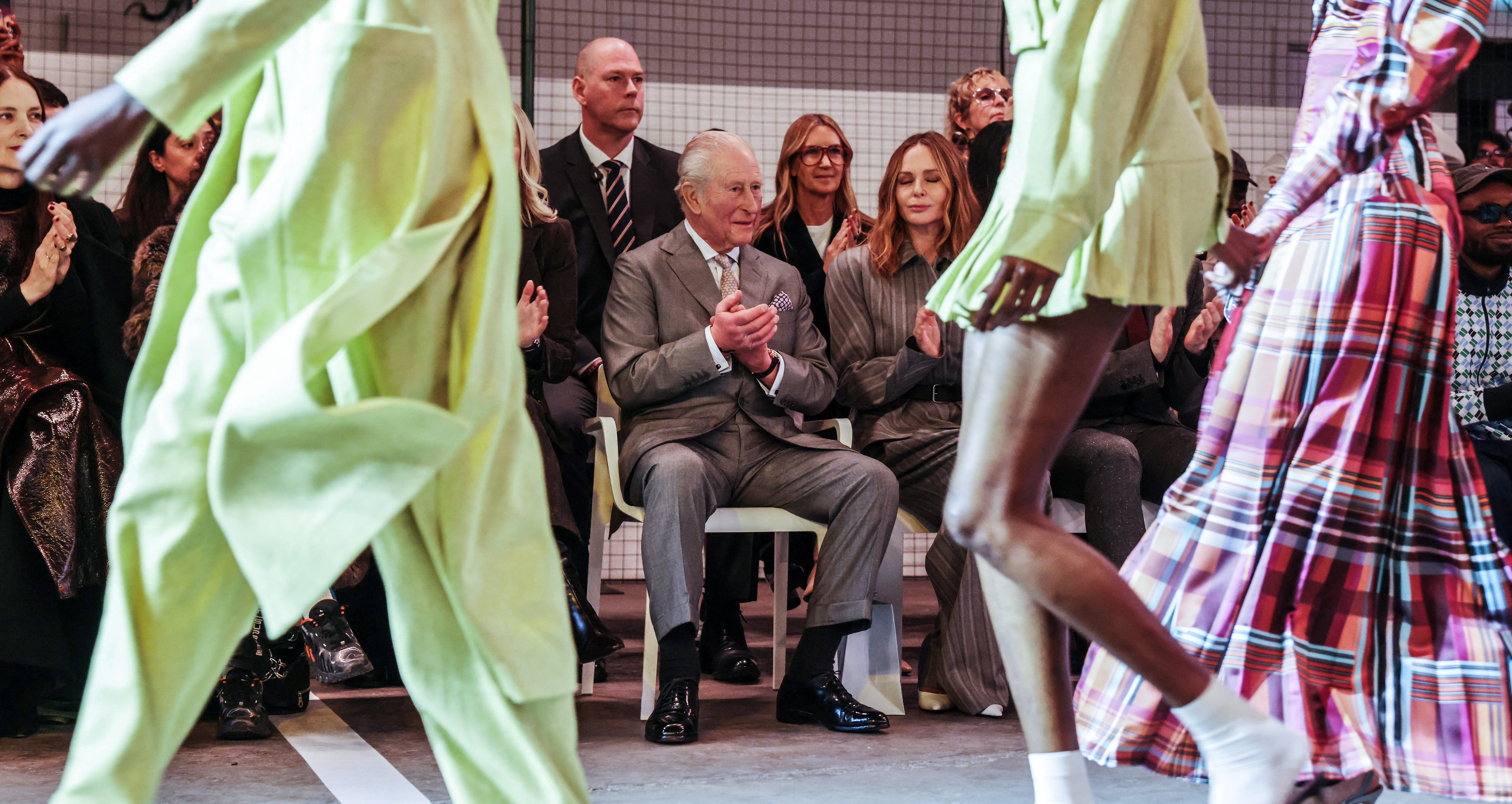 King Charles claps while attending the opening show of London Fashion Week.