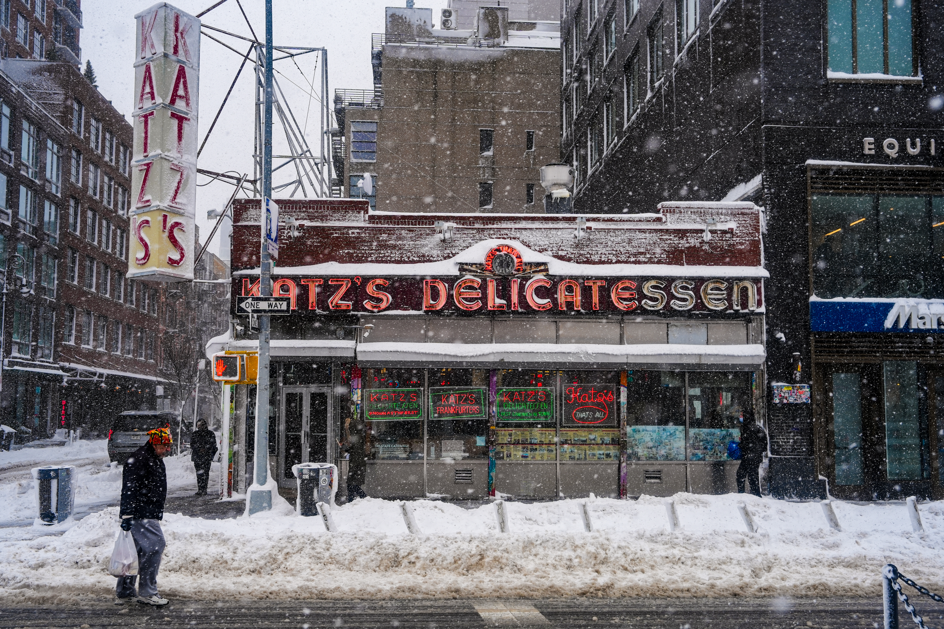 People walk past Katz's Delicatessen in the Lower East Side during a snowstorm in New York City.