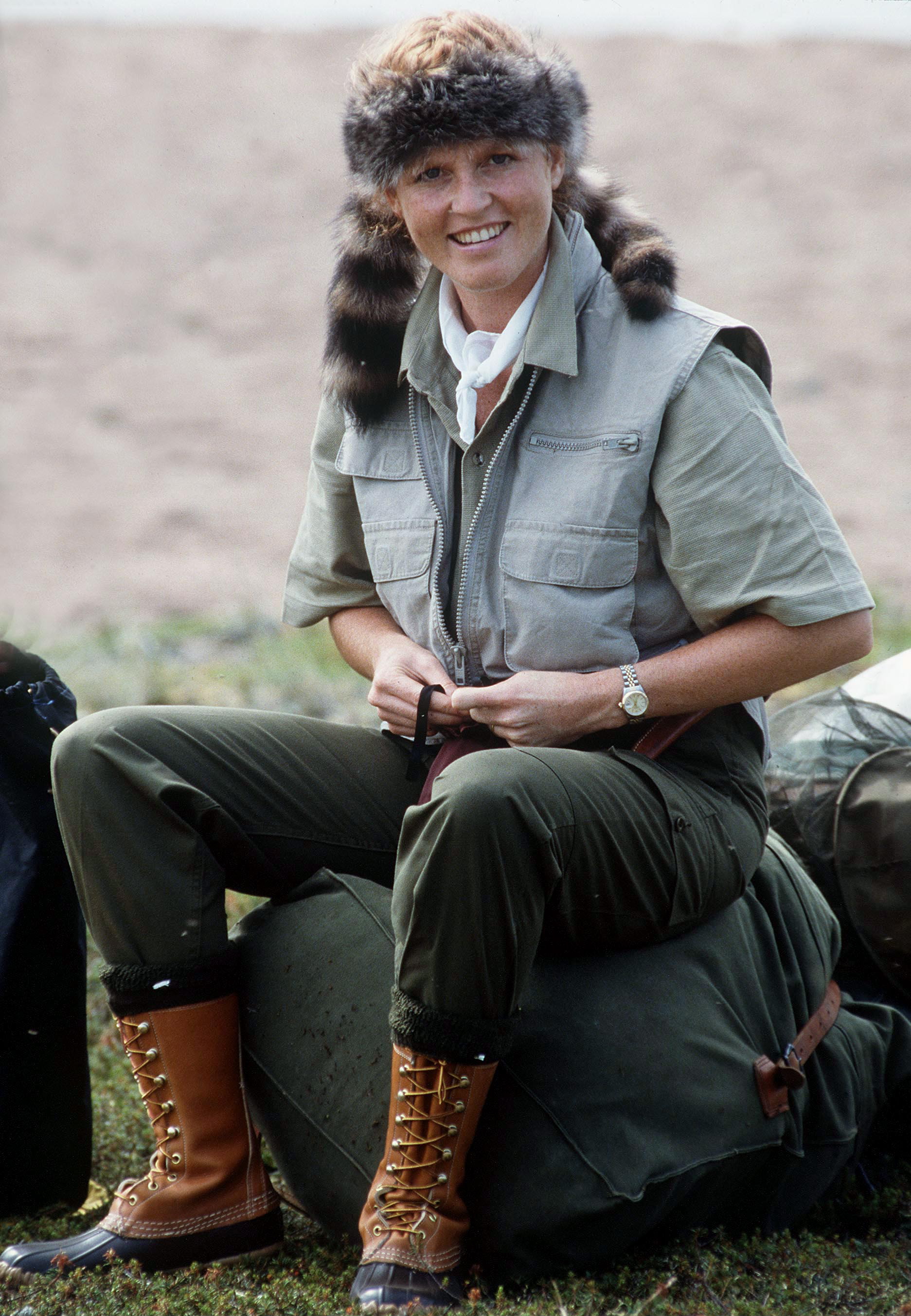 Sarah, Duchess of York, wearing a Davy Crockett style hat, shirt, vest, and boots, sits on gear at the start of a canoeing holiday in Canada.