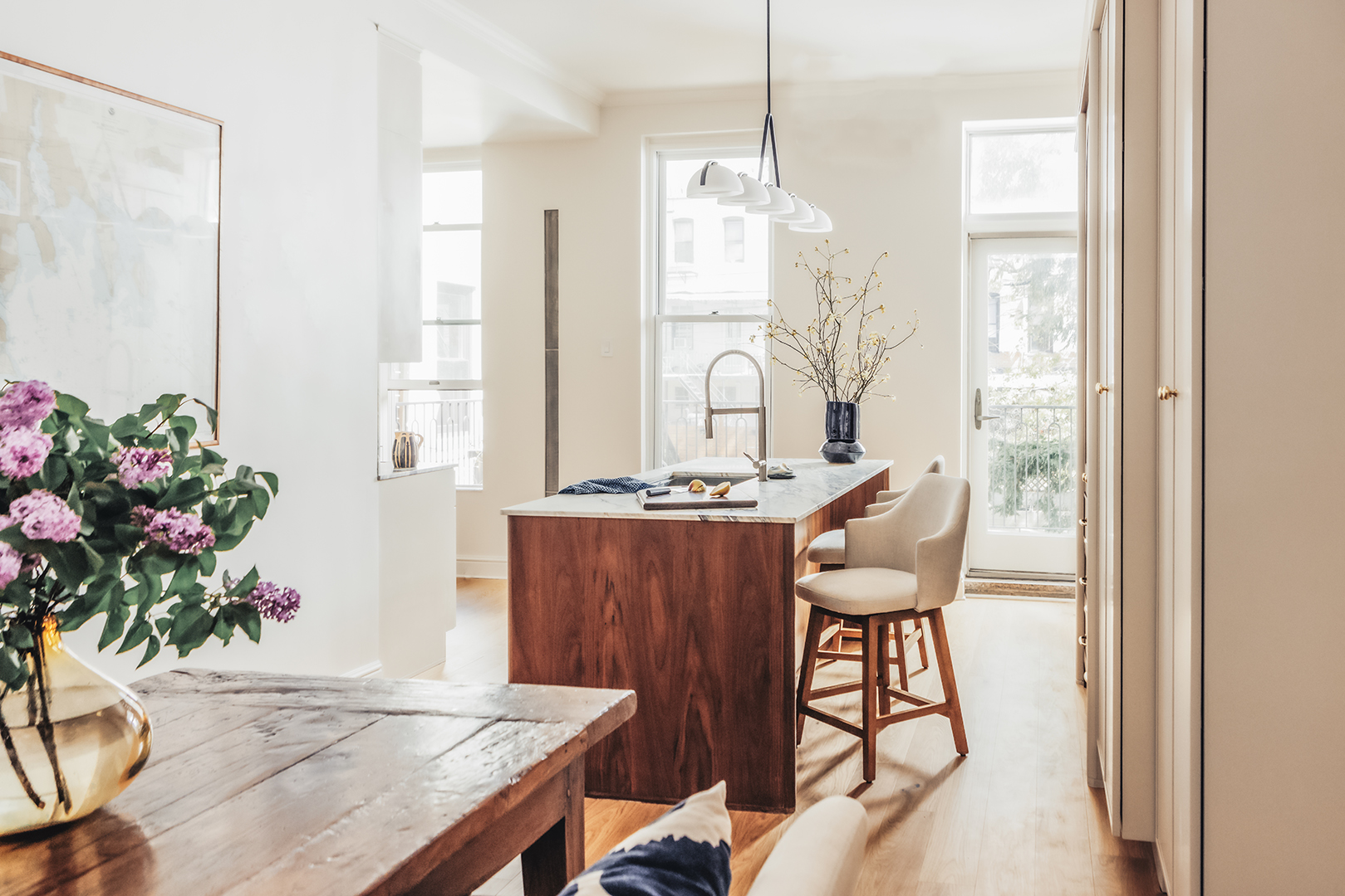 white kitchen with wood island and chairs