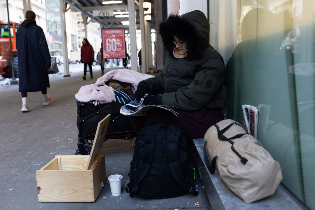 Tiffany Rosario keeps warm in Midtown with her service dog while she has to be out of her shelter during the day