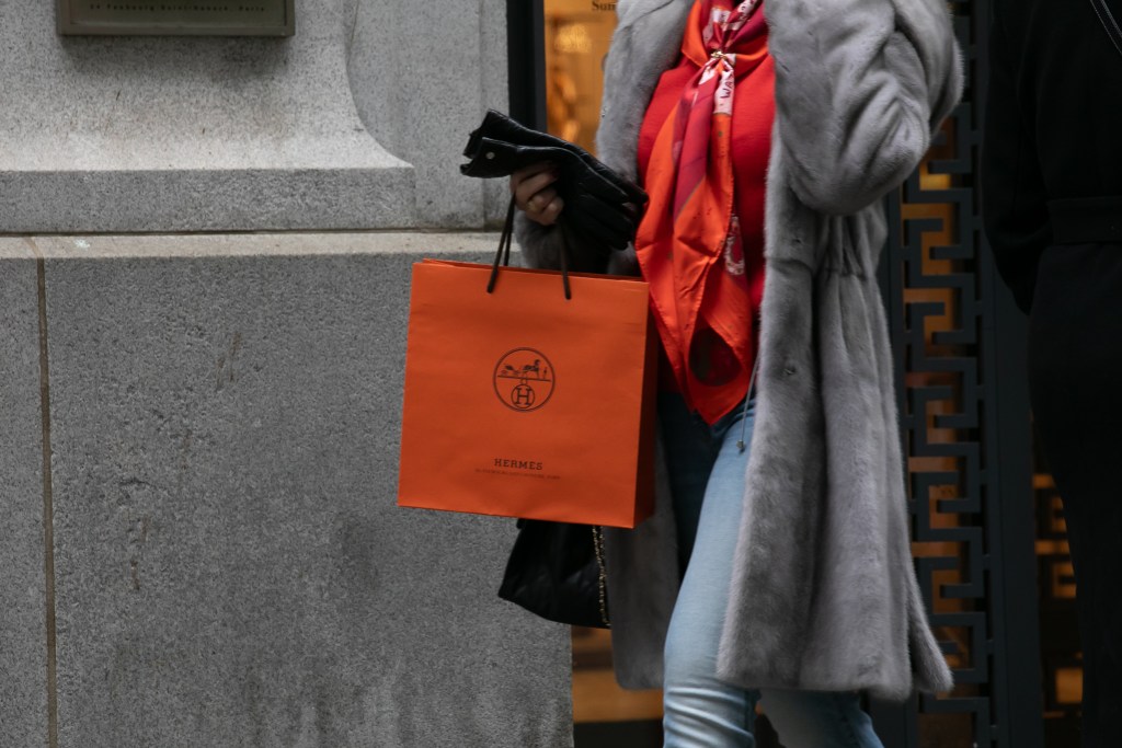 A shopper leaves the Hermès luxury good store across from the Stock Exchange,