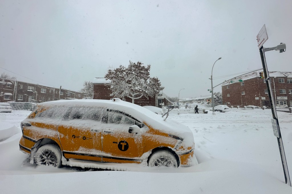 A cab is covered in snow in East Elmhurst, Queens during a blizzard,