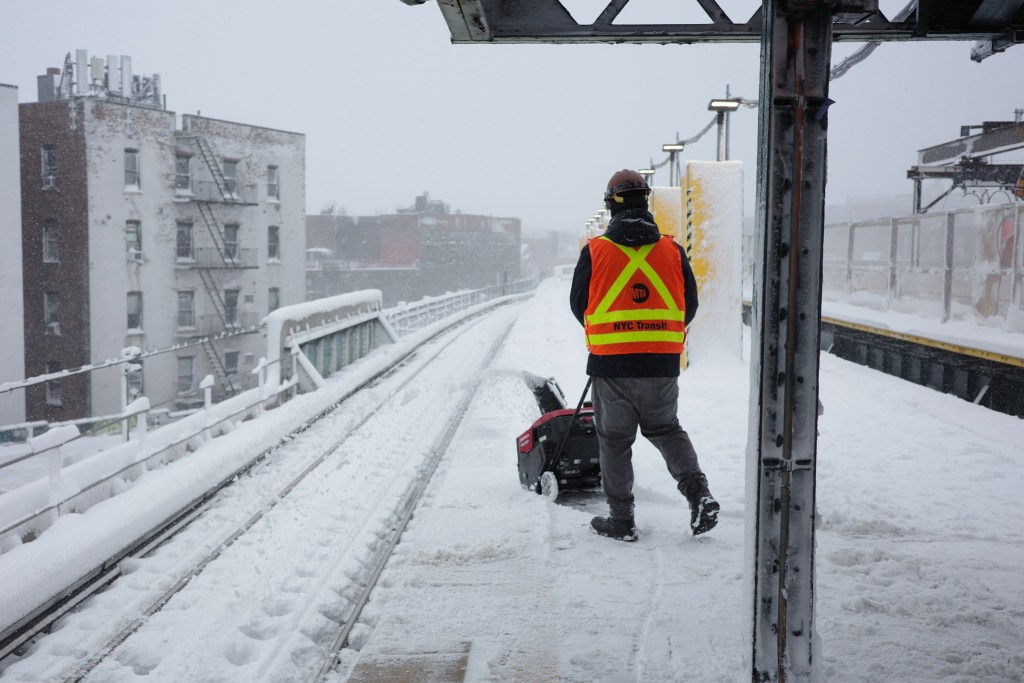 MTA workers clear the 7-train platform at 61st-Woodside in Queens,