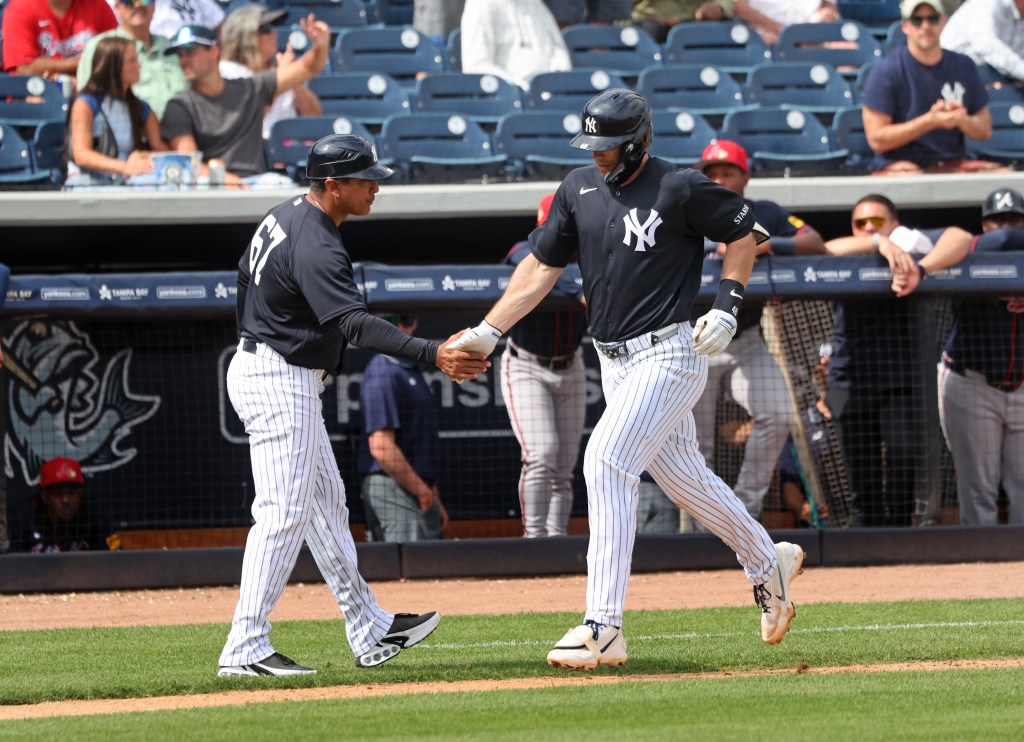 New York Yankees first baseman Paul Goldschmidt #48, shakes hands with New York Yankees third base coach Luis Rojas #67, as he jogs around the bases after hitting a solo homer in the 3rd inning.