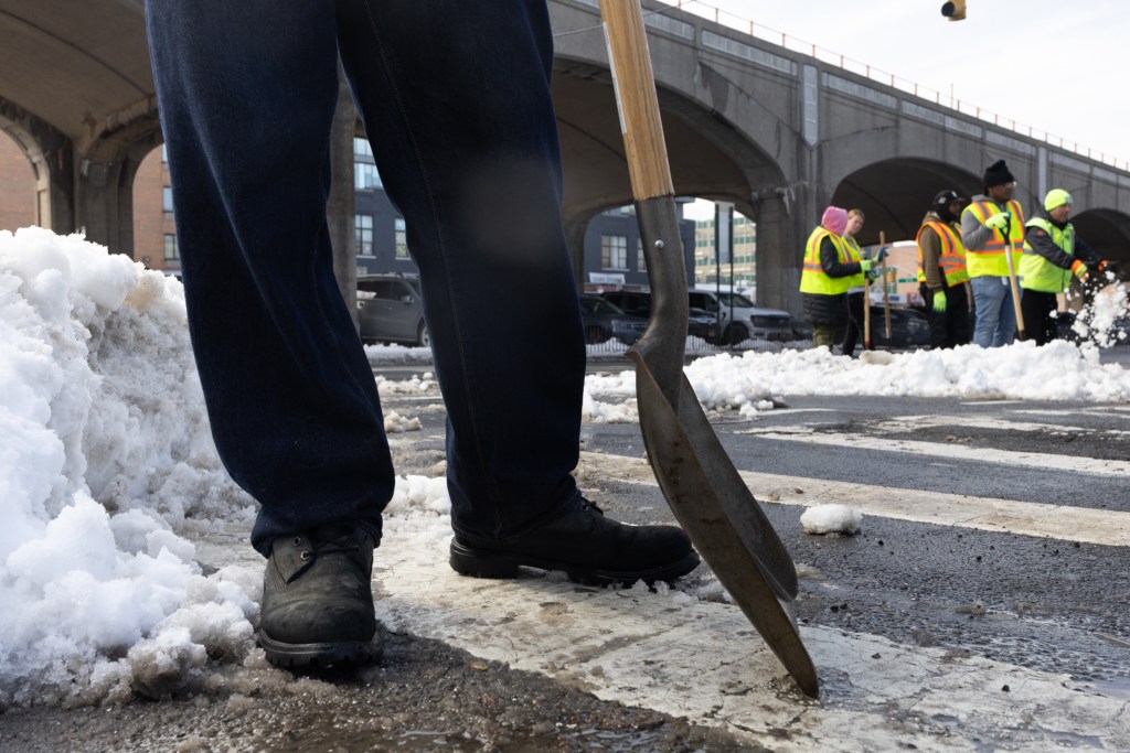 Temporary city workers shovel sidewalks and intersections in Sunnyside