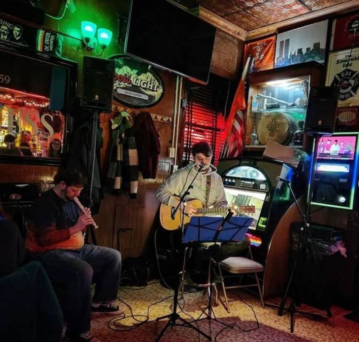 Drinkers enjoy Live Irish trad music at Irish Haven in Brooklyn as a man plays guitar and sings