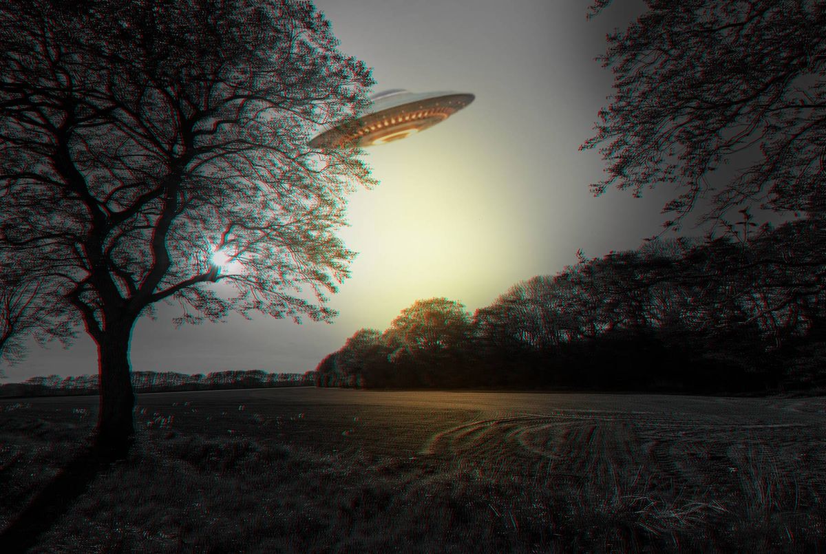 An artistic depiction of a saucer-shaped object hovering in the sky above a tranquil landscape, illuminated by the soft light of the setting sun. The scene features a silhouetted tree on the left, a body of water, and distant hills, all bathed in a serene twilight atmosphere.
