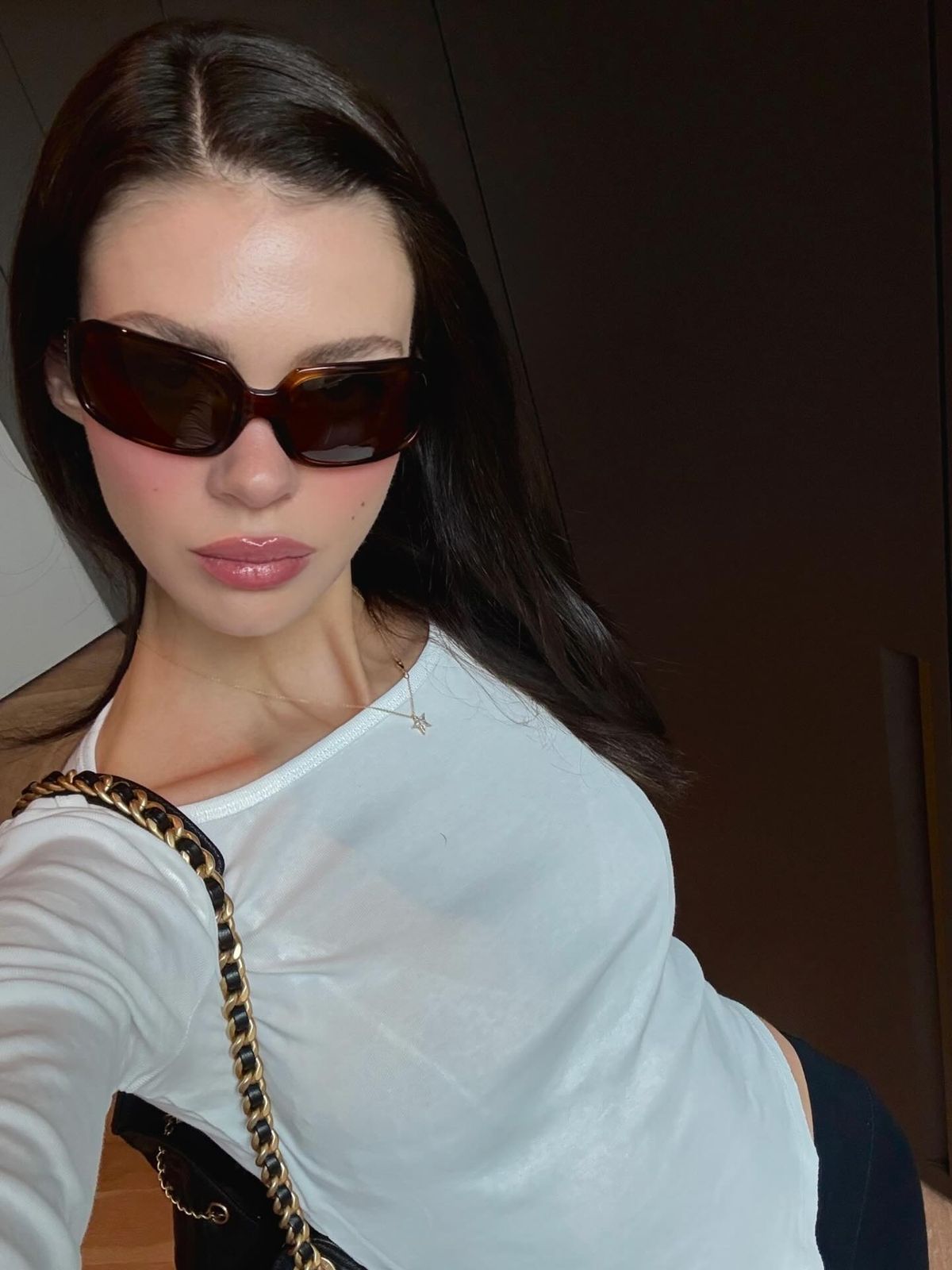 Selfie image of Nicola Peltz wearing shades and a white top