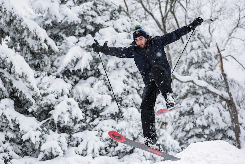 A man skis in the snow in Central Park.