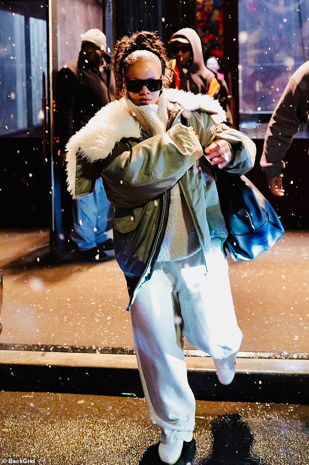 She layered the look over a cream fleece and casual jogging trousers while making her way to a waiting car