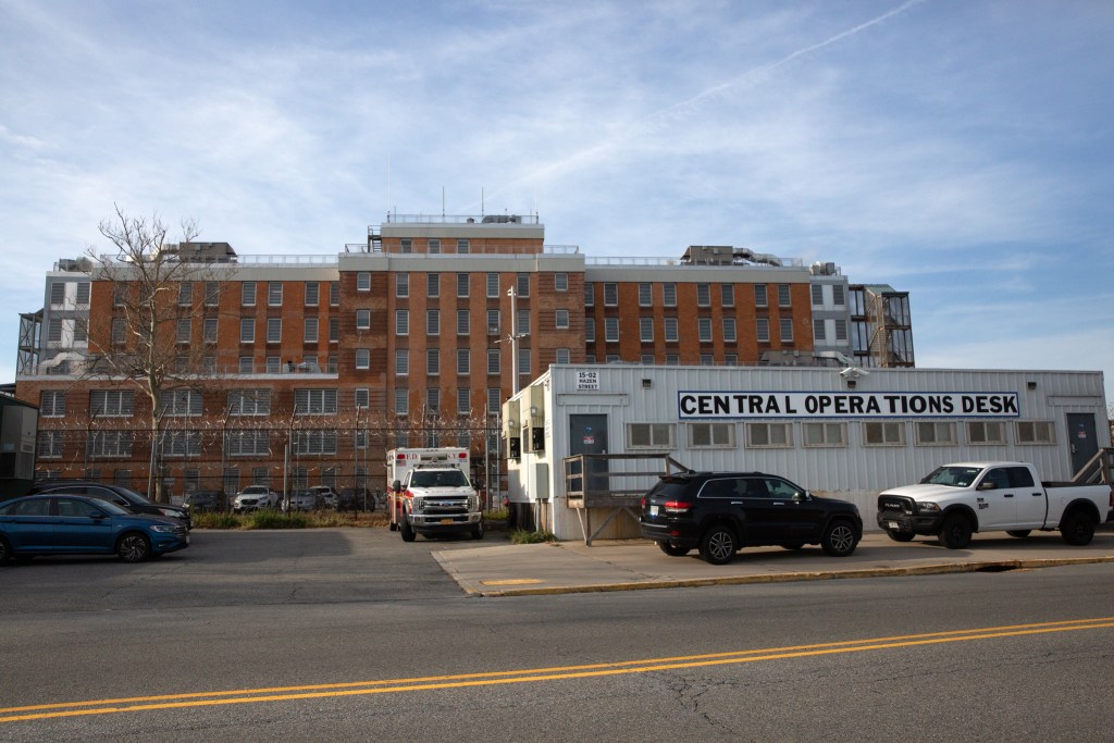 Workers overseeing daily functions on Rikers Island operate outside a jail facility,