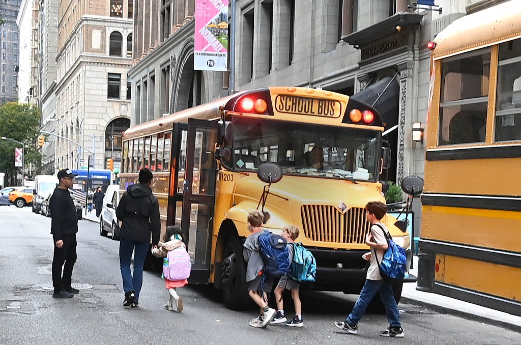 School children loading onto a yellow Consolidated school bus in New York City.