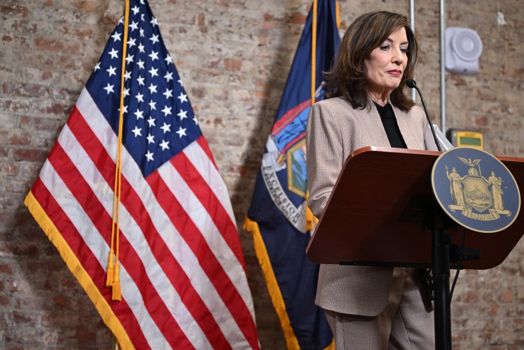 NYS Governor Kathy Hochul speaking at a podium with the New York State seal.