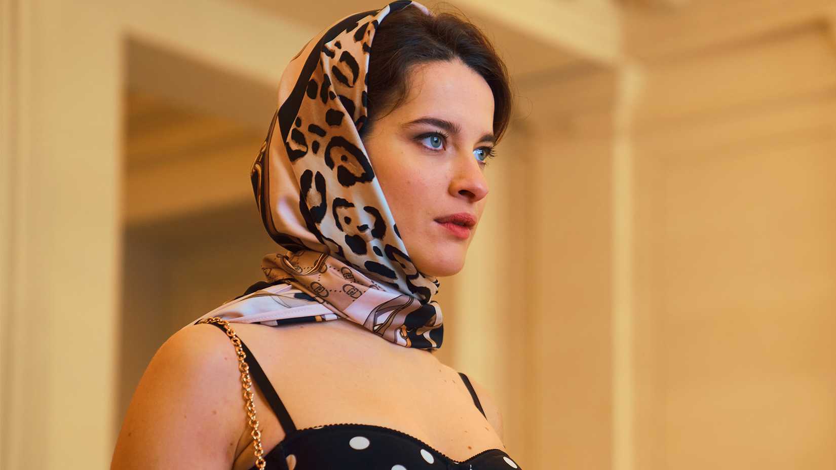 An image of a woman wearing a headscarf and looking ahead in Cash Queens