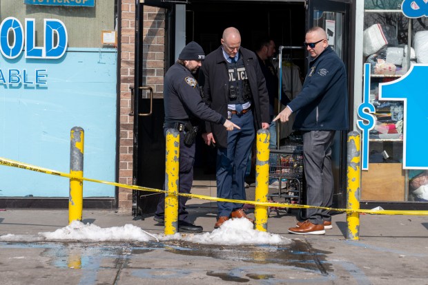 Police investigate on Saturday morning after Dominick Lowery, 31, was fatally shot in front of the Queens laundromat where he worked. 