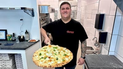 Vinny Corrao, owner of Americano Pizza Shop in Syosset, hefts...