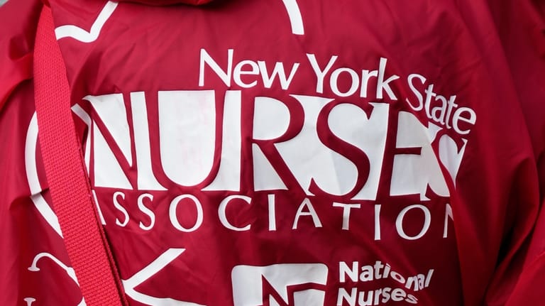 A woman wears clothes supporting striking nurses in front of...