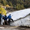 Bogus Basin employees unpack the snow blankets. They're made of polystyrene panels that fold out like an accordion. This year, the mountains in the West have had the lowest snow coverage in decades.