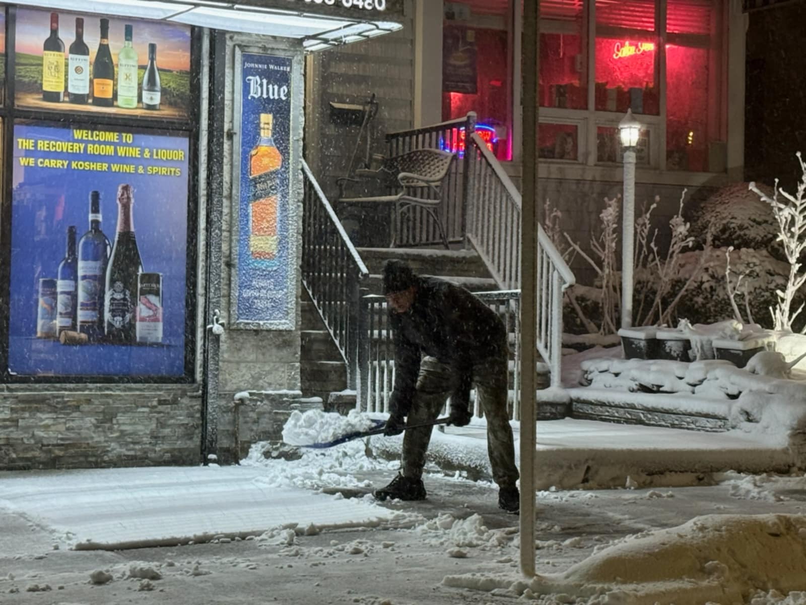 A man shovels early snow on Manor Road, at 7 p.m. on Sunday, Feb. 22, 2026.