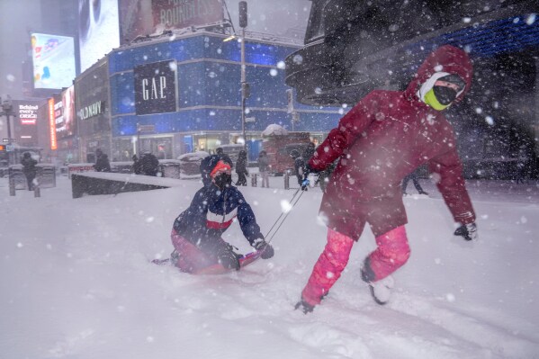 Hannah and Astrid Grimskog play in Times Square during a snow storm, Monday, Feb. 23, 2026, in New York. (AP Photo/Seth Wenig)
