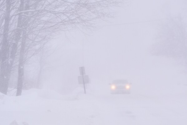 A pick-up truck drives in nearly white-out conditions during a winter storm, Monday, Feb. 23, 2026, in Derry, N.H. (AP Photo/Charles Krupa)